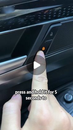 a person is pressing the button on a car's radio system to press and hold it for 5 seconds