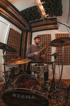 a man that is sitting in front of some drums