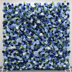 blue and white flowers are arranged on the wall