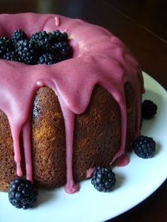 a bundt cake with berries and icing on a plate