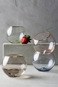 three glass vases sitting next to each other on top of a white countertop