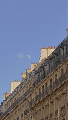 an old building with balconies and a clock on the top is seen against a clear blue sky