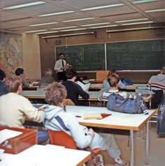 a classroom full of students sitting at desks with their backs turned to the side