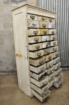 an old white cabinet with many drawers