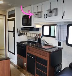 a kitchen with black appliances and white walls