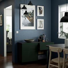 a dining room with blue walls and pictures on the wall