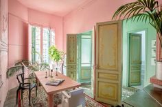 a room with pink walls and green doors