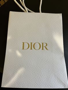 a white bag with the word dior on it sitting on top of a table