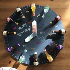 a clock made out of beer bottles on top of a wooden table with the words happy birthday written on it