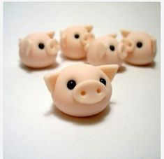 small pink pig figurines sitting on top of a white table next to each other