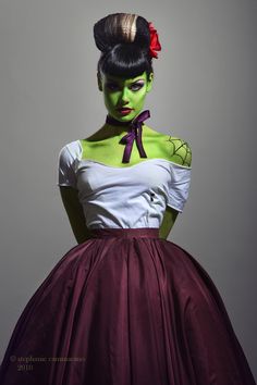 a woman in a dress with green paint on her face