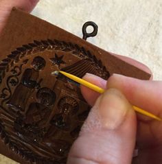 a person holding a pencil in their left hand and writing on a piece of wood