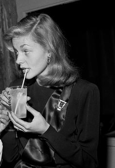 two women sitting next to each other drinking drinks