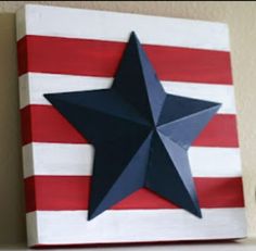 a red, white and blue star painted on a canvas next to a silver cup