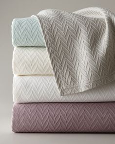 three folded blankets stacked on top of each other