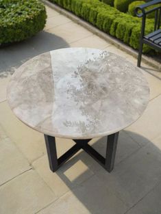 a white marble table sitting on top of a sidewalk