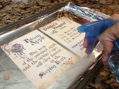 a person is holding a plastic bottle and some paper on top of a countertop