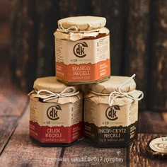 four jars of jam sitting on top of a wooden table