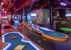 an indoor bowling alley with neon lights and slides