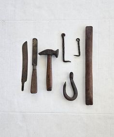 several old tools are laid out on a white tablecloth with the word it's spelled out in cursive writing