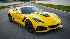 a yellow sports car driving down a race track