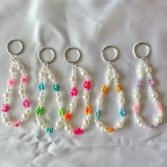 four key chains with beads and flowers on them