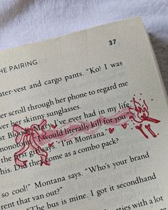 an open book with red writing on it