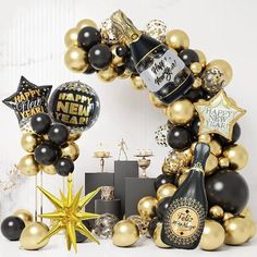 a black and gold new year's eve balloon arch