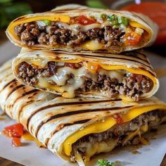 three quesadillas stacked on top of each other with cheese and ground beef