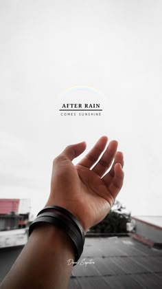 a person holding their hand up to the sky with an after rain sign above them