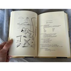 an open book with drawings on it in someone's hand and the pages are black