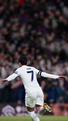 a man kicking a soccer ball on top of a field