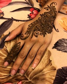 a close up of a person's hand with a henna tattoo on it