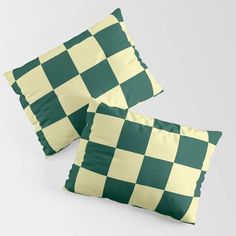 two green and yellow checkerboard pillows on a white background with the same pattern