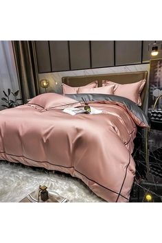 a bed with pink sheets and pillows in a room