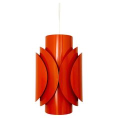 an orange lamp hanging from a ceiling fixture with two circles on the top and one circle at the bottom