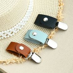 four different colored leather key fobs on top of a straw hat