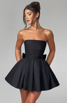 THE dress of the season has landed and you're going to be obsessed. Meet Katrina, our dreamy mini with a pretty, voluminous skirt and waist cinching bodice. Fastening with a zip to the back, tie with an oversized bow to complete the look for perfect feminine drama. 



Colour: Black.

Premium non-stretch cotton blend fabric.

Fully lined.

Strapless ruched bodice with boning.

Waist cinching.

Oversized tie to create bow detail to back.

Voluminous skirt with tulle lining.

Zip fastening to the