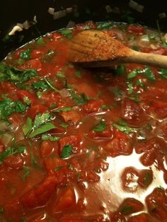 a pot filled with lots of food and a wooden spoon