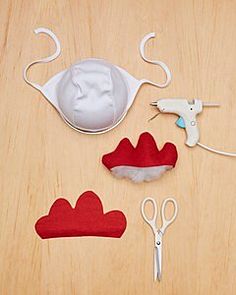 sewing supplies laid out on a wooden surface with scissors, thread and felt pieces in the shape of clouds