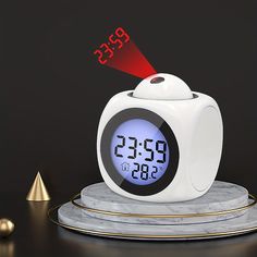 an alarm clock on a marble stand with red light coming from it's top