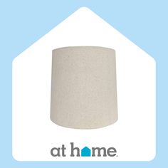 a white lamp shade sitting on top of a light blue background with the words at home written below it