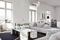 a living room filled with white furniture and lots of pillows on top of it's couches