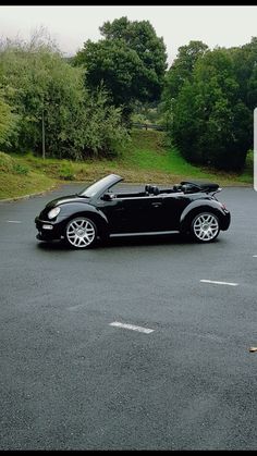 a black convertible car parked in a parking lot