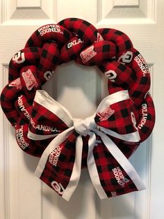 a red and black wreath with the words north carolina on it hanging on a door