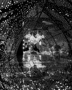 black and white photograph of chandelier in an indoor venue with lights on the ceiling