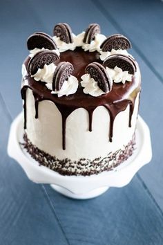 a chocolate cake with oreo cookies and white frosting on top sitting on a plate