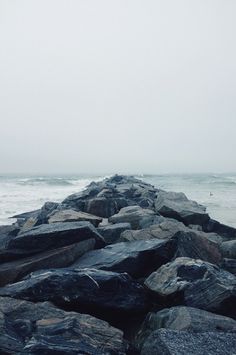 a person standing on rocks near the ocean