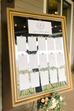 a wedding seating chart is displayed in front of a door with flowers and greenery