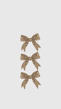 three bows with leopard print on them are hanging from the side of a white wall